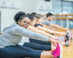 Adults in fitness class stretching for the BetterTogether weight loss challenge with friends